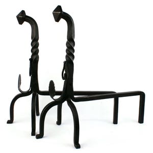 May include: Pair of black wrought iron fireplace andirons. Each andiron features a twisted central column, a decorative leaf-like element, and a diamond-shaped top. The andirons have a sturdy base with four legs and a horizontal bar.