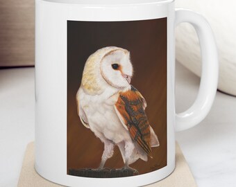 May include: White ceramic mug with a brown background image of a barn owl with white feathers and orange markings. The owl is looking to the side and has its wings folded.