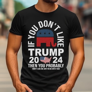 Peut inclure: T-shirt noir avec un motif blanc qui dit "Si vous n'aimez pas Trump 2024, vous n'aimerez probablement pas moi non plus, et je suis d'accord avec ça". Le motif comprend également un éléphant rouge, blanc et bleu et un petit drapeau américain.