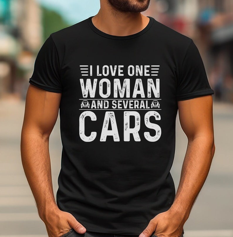 K&ouml;nnte beinhalten: Schwarzes T-Shirt mit wei&szlig;em Text, der "Ich liebe eine Frau und mehrere Autos" lautet.
