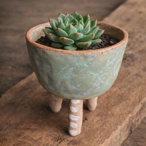 May include: A trio of ceramic mugs with a speckled, matte finish in cream, light grey, and dark grey. Each mug features a minimalist design and a rounded handle.