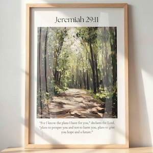 Op de afbeelding: Een ingelijste print met een schilderij van een zonnig bospad. De tekst "Jeremiah 29:11" staat bovenaan, met een citaat eronder: "Want Ik weet, welke gedachten Ik over u heb, spreekt de HEERE, gedachten van vrede en niet van kwaad, om u toekomst en verwachting te geven."