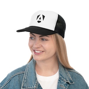 May include: Black and white trucker hat with a geometric "A" logo on the front. The hat features a black brim and mesh back, with a white front panel. The logo is a bold, angular design in black.