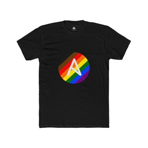 May include: Black t-shirt with a circular design in rainbow colours and a white letter "A". The design includes brown, red, orange, yellow, green, blue, and purple. The shirt has a crew neck.