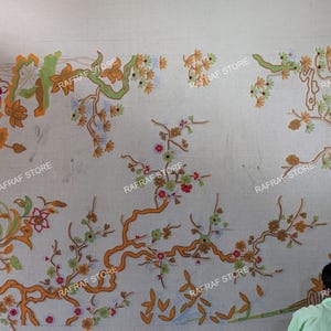 May include: A large, off-white textile with an intricate floral design in shades of orange, green, and red. The design features branches, leaves, and flowers. The text "RAFRAF STORE" is repeated across the image.