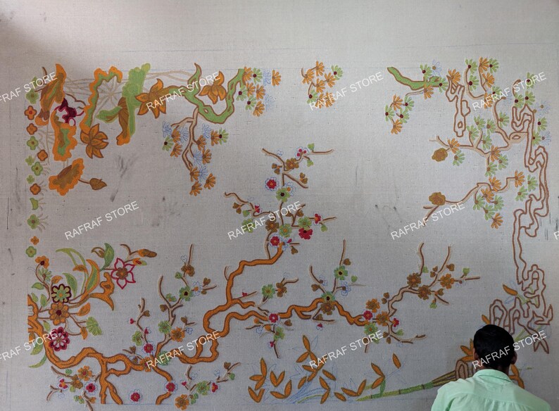 May include: A large, off-white textile with an intricate floral design in shades of orange, green, and red. The design features branches, leaves, and flowers. The text "RAFRAF STORE" is repeated across the image.