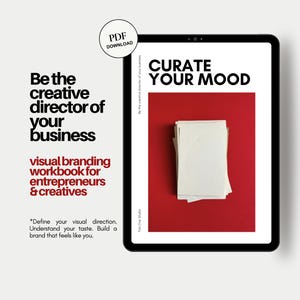 May include: A digital tablet displaying a visual branding workbook titled Curate Your Mood with a stack of white papers on a red background. Text on the screen includes Be the creative director of your business and Tab One Studio.
