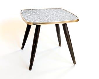 Mesita auxiliar vintage de mediados de siglo de la década de 1960: Soporte para plantas con tablero de linóleo geométrico y detalles dorados.