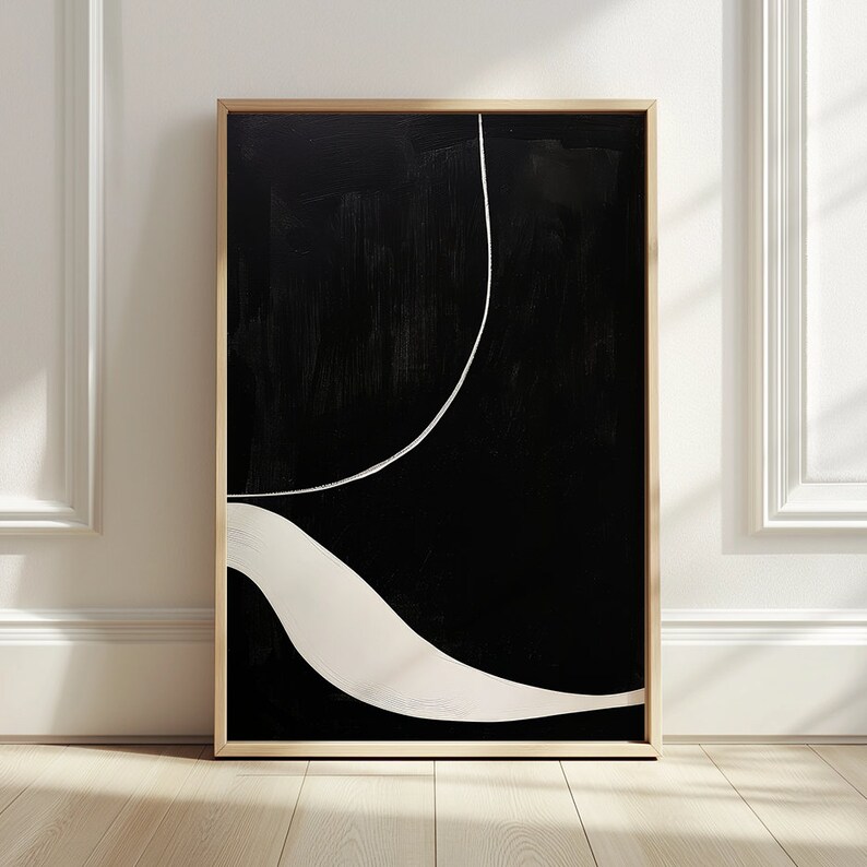 K&ouml;nnte beinhalten: Abstrakter Kunstdruck in einem Holzrahmen. Das Kunstwerk zeigt einen schwarzen Hintergrund mit einer wei&szlig;en, gebogenen Linie und einer wei&szlig;en, wellenf&ouml;rmigen Form. Das St&uuml;ck hat ein minimalistisches Design und eine moderne &Auml;sthetik.