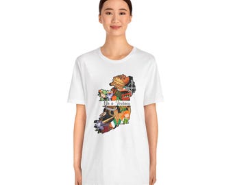 May include: A white short-sleeved t-shirt featuring a graphic of the island of Ireland filled with various colorful illustrations and the text "On a Journey" written in a script font across the center of the map design.