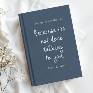 Peut inclure: Un journal à couverture rigide bleu foncé avec du texte blanc qui indique : Letters to my Brother because I'm not done talking to you, Love, Lindsay. La couverture du livre présente un mélange de polices serif et manuscrites centrées.