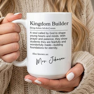 May include: White ceramic mug with the text "Kingdom Builder" and a definition. The definition describes shaping young hearts and minds. The mug also includes the name "Mrs. Johnson" in cursive.