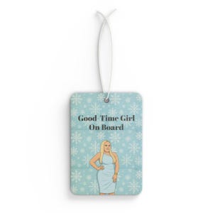May include: Rectangular air freshener with a light blue background and white snowflake pattern. The text "Good-Time Girl On Board" is printed on the front. A cartoon illustration of a woman in a blue dress is also featured.
