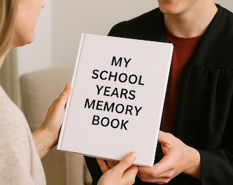 Pode incluir: Um livro branco com o título "MY SCHOOL YEARS MEMORY BOOK" em texto preto é segurado por duas pessoas. Uma pessoa está vestida com uma toga preta. O fundo é neutro.