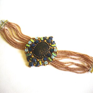 Armband mit Strasssteinen und Schmuckornament in rosé, blau und goldenen Farben, gefädelt und verstellbare Weite