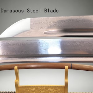 May include: A Damascus steel blade with a visible wavy pattern and a sharp edge, positioned above a wooden sword scabbard resting on a light-colored stand. The text "Damascus Steel Blade" is printed in black in the upper left corner of the image.