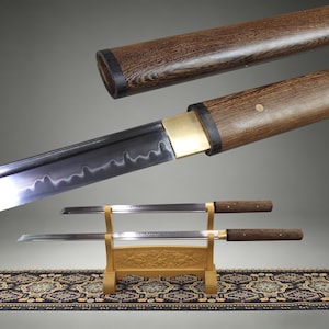 May include: A Japanese katana sword with a wooden scabbard and handle. The blade is silver with a wavy edge. The sword is displayed on a wooden stand with a decorative rug in the background.