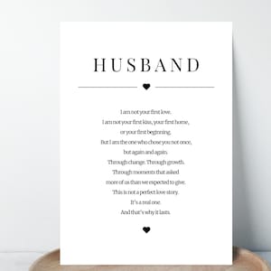 May include: A white print with the word "HUSBAND" at the top, followed by a heart symbol and a poem about love. The text is in a simple, elegant font, suitable for a wedding or anniversary gift.
