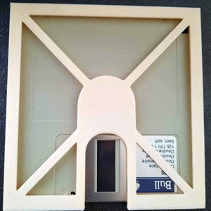 Puede incluir: Una caja de disquete de plástico blanco con una ventana transparente para ver el disco. La caja tiene una etiqueta que dice "Bull 0 Double Density Double Sided 135 TPI 1.1 Sect: soft".