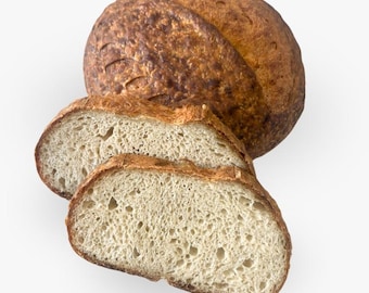 May include: A round loaf of sourdough bread with a dark, golden-brown crust and a visible score line, accompanied by two thick, sliced pieces showing an airy, off-white interior crumb with small holes throughout the baked dough.