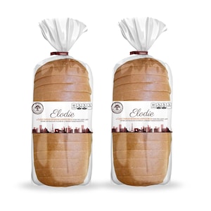 May include: Two loaves of sliced bread in clear plastic packaging. Each loaf has a label that reads "Elodie" with a cityscape design. The bread is light brown and appears to be a sandwich loaf.
