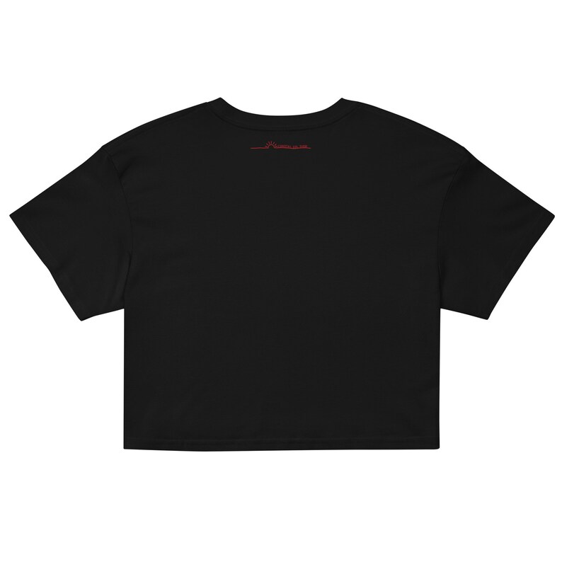 May include: Black cropped t-shirt with short sleeves. The shirt has a small red logo on the back.