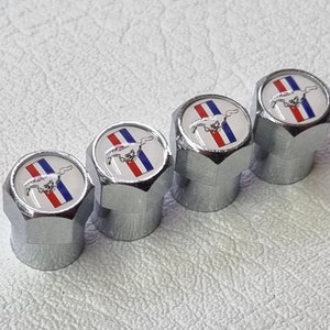 May include: Set of four chrome valve stem caps with a white, red, and blue Mustang logo.