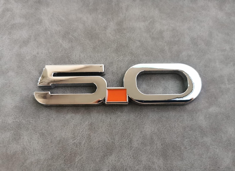 May include: Chrome 5.0 emblem with an orange square in the center.