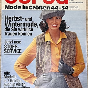 Könnte beinhalten: Ein Magazin-Cover für Burda, ein Modemagazin, das eine Frau zeigt, die eine braune Weste, ein gelbes Hemd und schwarze Handschuhe trägt. Das Magazin-Cover trägt den Titel "Burda Mode in Größen 44-54" und zeigt den Text "Herbst- und Wintermode, die Sie wirklich tragen können." Das Magazin-Cover zeigt auch den Text "Jetzt neu: STOFF-SERVICE".