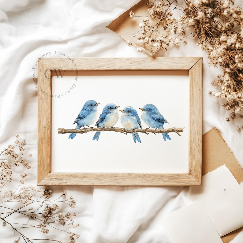 May include: A framed watercolour painting of four bluebirds perched on a branch. The birds are facing to the right and have light blue bodies and dark blue wings. The background is white.