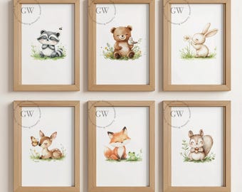 Peut inclure: Six cadres en bois clair présentent des aquarelles d'animaux de la forêt : un raton laveur, un ours, un lapin, un cerf, un renard et un écureuil. Chaque animal est dans un cadre naturel avec de l'herbe et des fleurs.