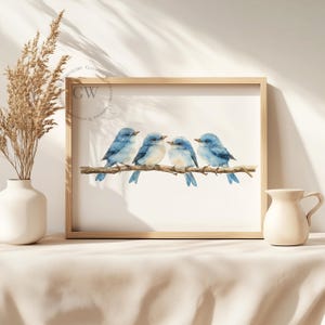 May include: A watercolour painting of four bluebirds perched on a branch. The birds are facing to the right and have light blue bodies with darker blue wings and tails. The painting is framed in a light wood frame.