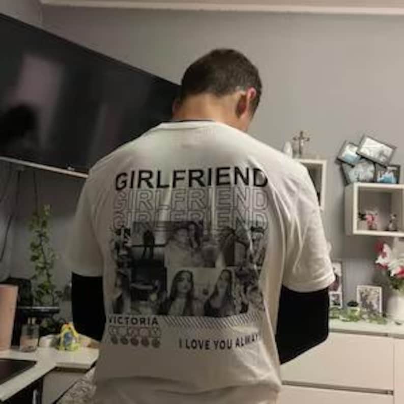 May include: White t-shirt with the word "GIRLFRIEND" printed multiple times in a stacked design. Below the word are several black and white photos of women. The text "I LOVE YOU ALWAYS" is printed at the bottom.