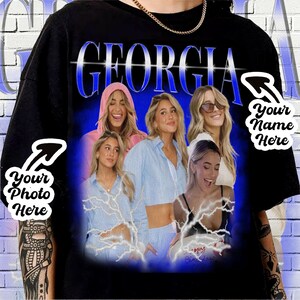 May include: A black t-shirt with a blue and white graphic print of five women. The graphic includes the word "GEORGIA" in a blue and white font. The graphic also includes lightning bolts and a birthday cake. The t-shirt is customizable with a photo and name.