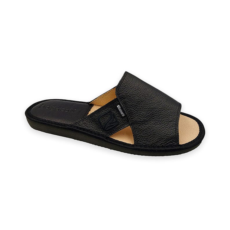 May include: A black slide sandal with a textured upper strap featuring the brand name Bosaco and a logo. The footbed is tan with a black heel section embossed with the brand name. The sole is black with a rounded toe and open-toe design.