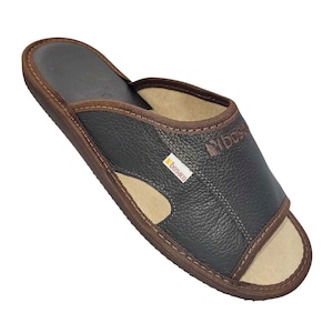 May include: A dark brown leather slipper with a light brown interior and trim. The slipper has an open-toe design and the brand name "bosaco" is visible on a small tag.