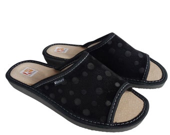 Cómodas zapatillas de estar por casa de mujer en color negro, con puntera abierta, confeccionadas en piel serraje con la parte superior perforada y suela de goma.