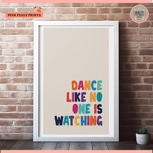 May include: A colourful typography print with the text "Dance like no one is watching" in a white frame against a brick wall background.