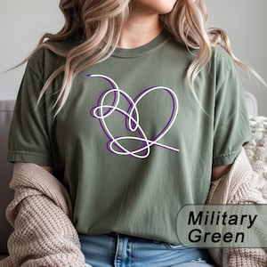 Könnte beinhalten: Ein militärgrünes Kurzarm-T-Shirt mit einer Grafik aus einer durchgehenden, verschlungenen Linie, die ein Herz in Weiß und Lila bildet. Das Shirt hat einen Rundhalsausschnitt und eine lockere Passform, mit dem Text Military Green in der Ecke.