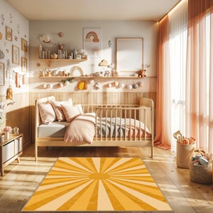 Könnte beinhalten: Ein gelber und orangefarbener Sonnenstrahlen-Teppich in einem Kinderzimmer mit einem Holzbettchen und einem Regal mit Dekorationen.