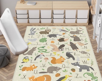 May include: A beige children's rug featuring an alphabet and animal illustrations. The rug includes images of a fox, squirrel, owl, and other animals, with each animal paired with a letter of the alphabet. The rug is designed for a child's room.