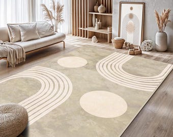 May include: A rectangular area rug featuring a beige and cream colour palette with a pattern of large solid circles and concentric semi-circular arch lines. The rug has a textured, mottled surface finish and is laid out on a wooden floor.