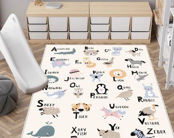 May include: A cream-colored children's alphabet rug featuring animal illustrations and corresponding letters. The rug includes a variety of animals, such as an alligator, bear, cat, dog, elephant, fox, goose, horse, iguana, koala, lion, mouse, penguin, rabbit, sheep, tiger, unicorn, yak, zebra, and whale.