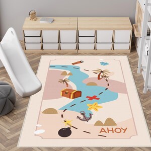 May include: A light beige children's play rug with a colourful pirate treasure map design. The rug features a blue river, a treasure chest, a red cross, a yellow starfish, an anchor, a bomb, and the word "Ahoy!"