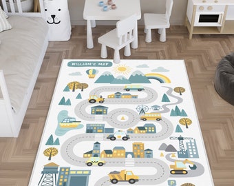 May include: A rectangular area rug featuring a white background with a colorful city map illustration. The design includes winding gray roads, buildings, vehicles, trees, mountains, a sun, and a rainbow. The text WILLIAM'S MAP is printed at the top.