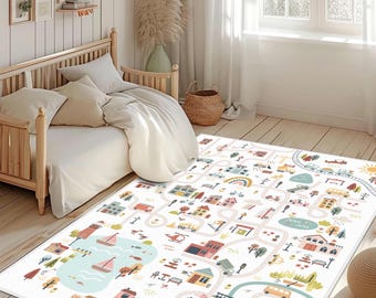 May include: A rectangular area rug featuring a colorful illustrated town map with winding roads, houses, vehicles, a lake with sailboats, trees, and a rainbow. The design is printed on a white background with soft pastel tones throughout the pattern.