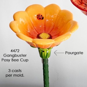 May include: A vibrant, orange flower-shaped cup with a ladybug accent. The cup has a yellow center and a green stem. The text on the image reads "4472 Gangbuster Posy Bee Cup" and "3 casts per mold."