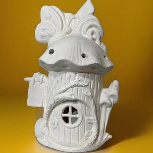 May include: White ceramic fairy house with a mushroom roof, a door, and a sign that says "Welcome to Fairyland".