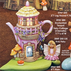 May include: A pink and white teapot fairy cottage with a yellow roof, a light blue door, and a fairy with pink wings and a pink dress. The cottage is 11 inches wide and 8 inches tall.