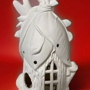 May include: White ceramic fairy house with a leaf-shaped roof and a window with a lattice design. The house has a small door and a chimney.